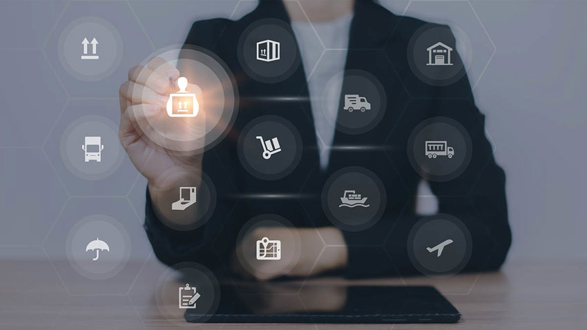 A woman in a suit from the neck down, sitting at a desk. White icons are overlaid over the image, and she is pointing to one, which is lit up.